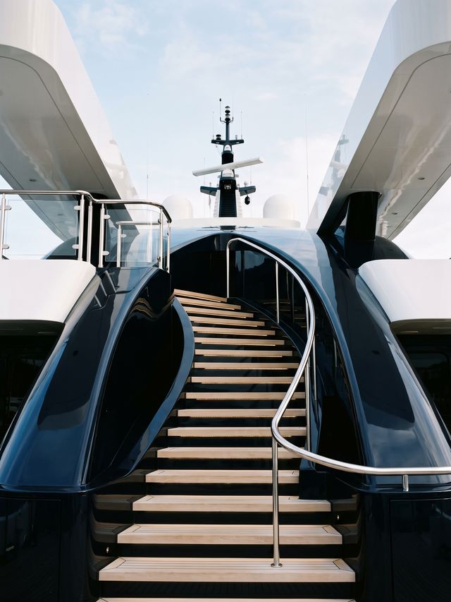Sculpted staircase between the decks of a navy-hulled superyacht